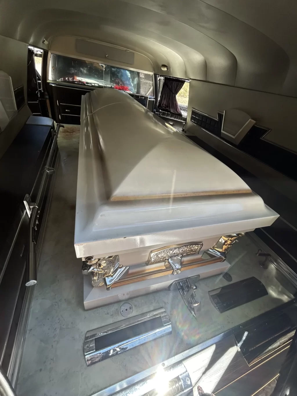 Casket in the back of a 1967 Cadillac hearse