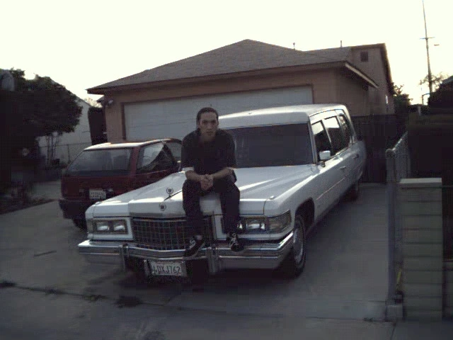 Ben sitting on the hood of his 1976 Cadillac Superior Hearse Combo